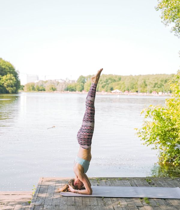 Woman performing a calm yoga pose in a dark, serene environment.